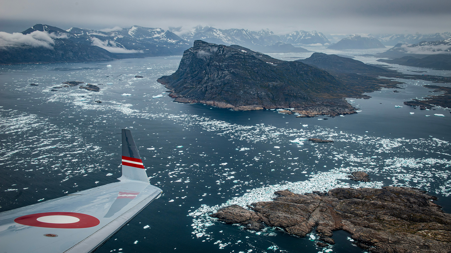 A Challenger aircraft flies over the vast wilderness of Greenland