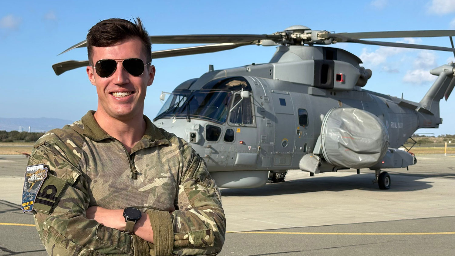 The Tactical Mission Commander, 820 Naval Air Squadron, stands in front of a Merlin Crowsnest
