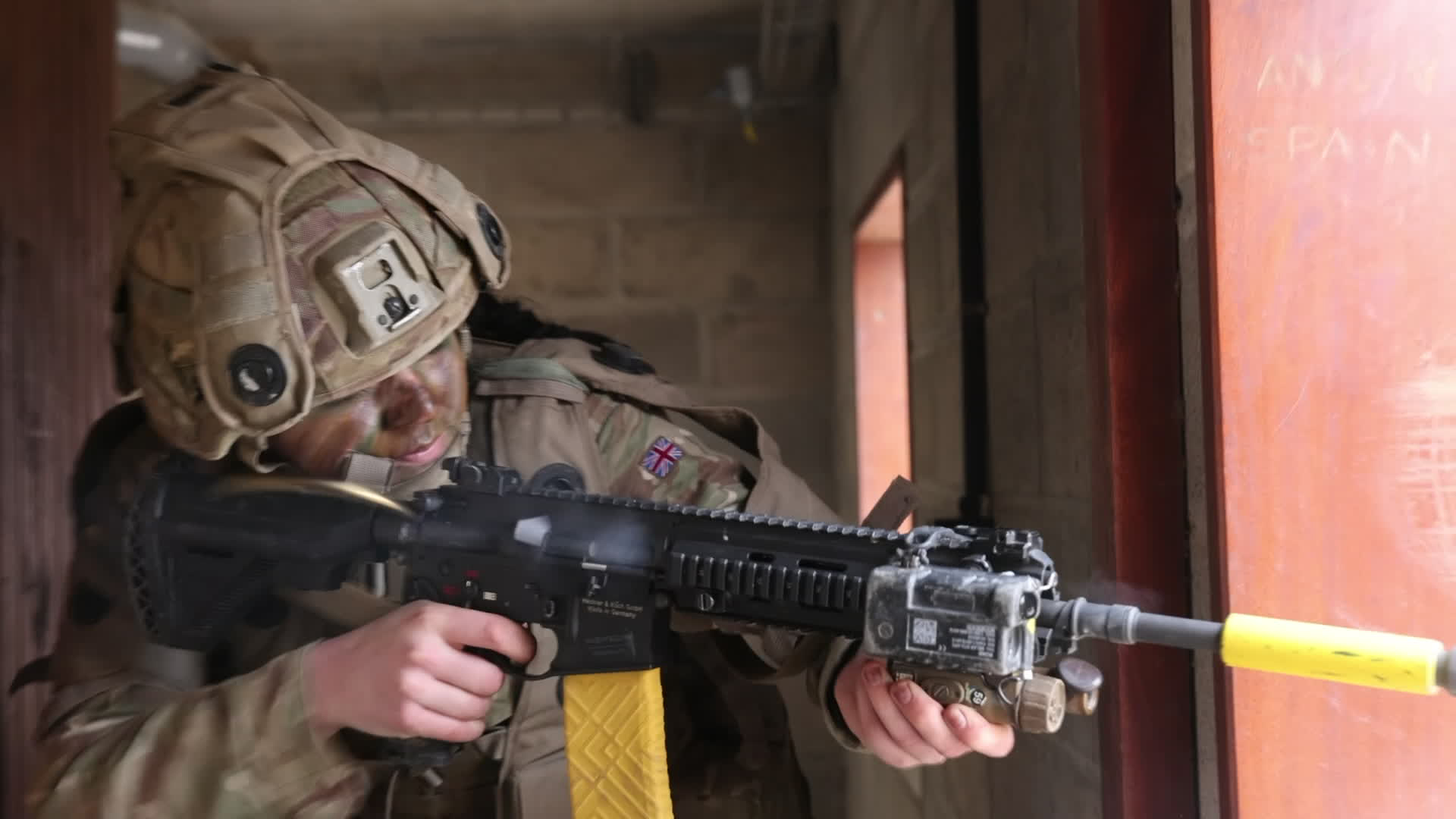 Kingsman Lilly Aspirnall opens fire from the interior of a building, keeping well back from windows and doorways to help keep her concealed