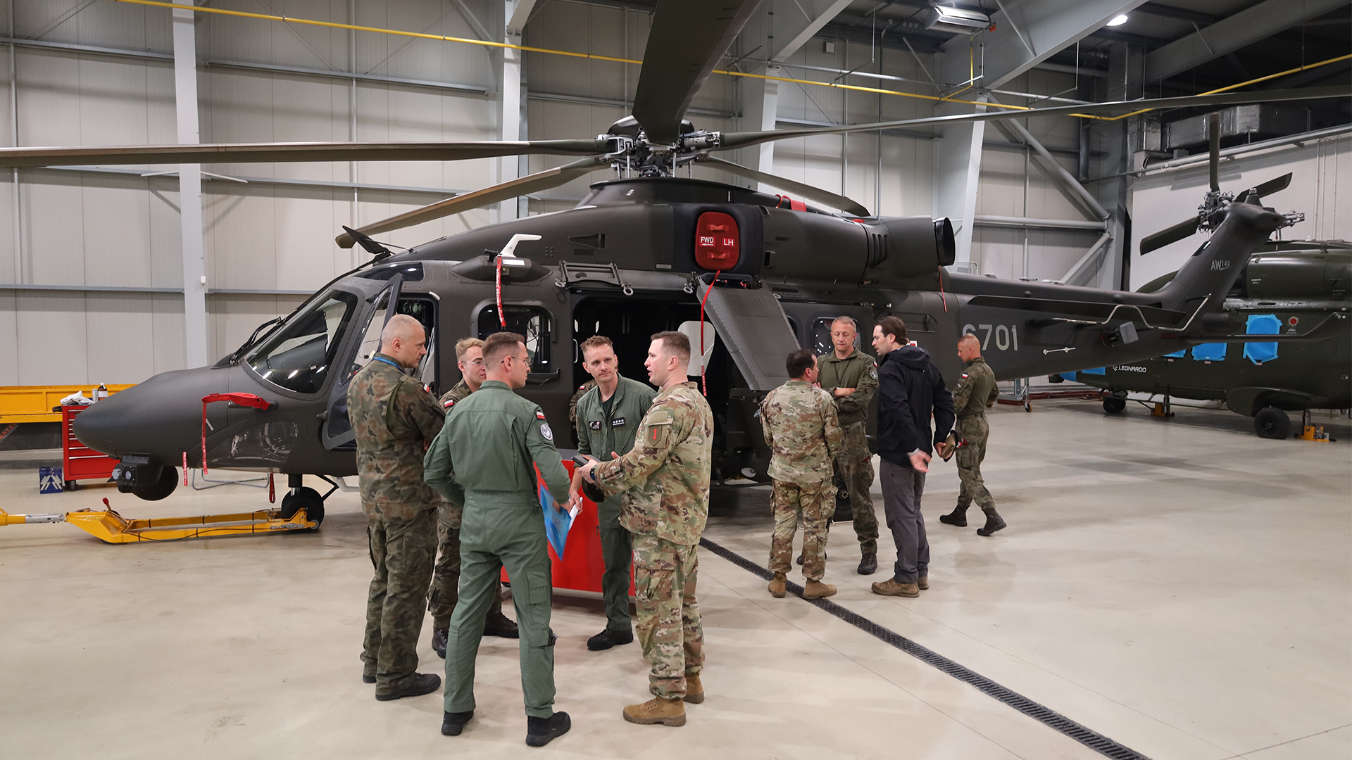 Soldiers from the 25th Polish Air Cavalry Brigade discuss the capabilities offered by their new helicopter with visiting US personnel