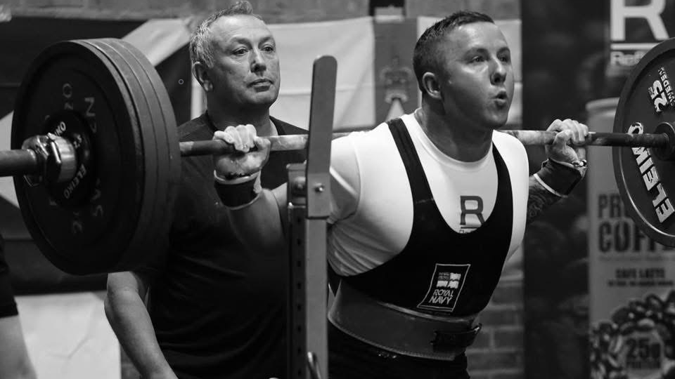 Powerlifter Petty Officer Wesley McGuinness squatting a barbel