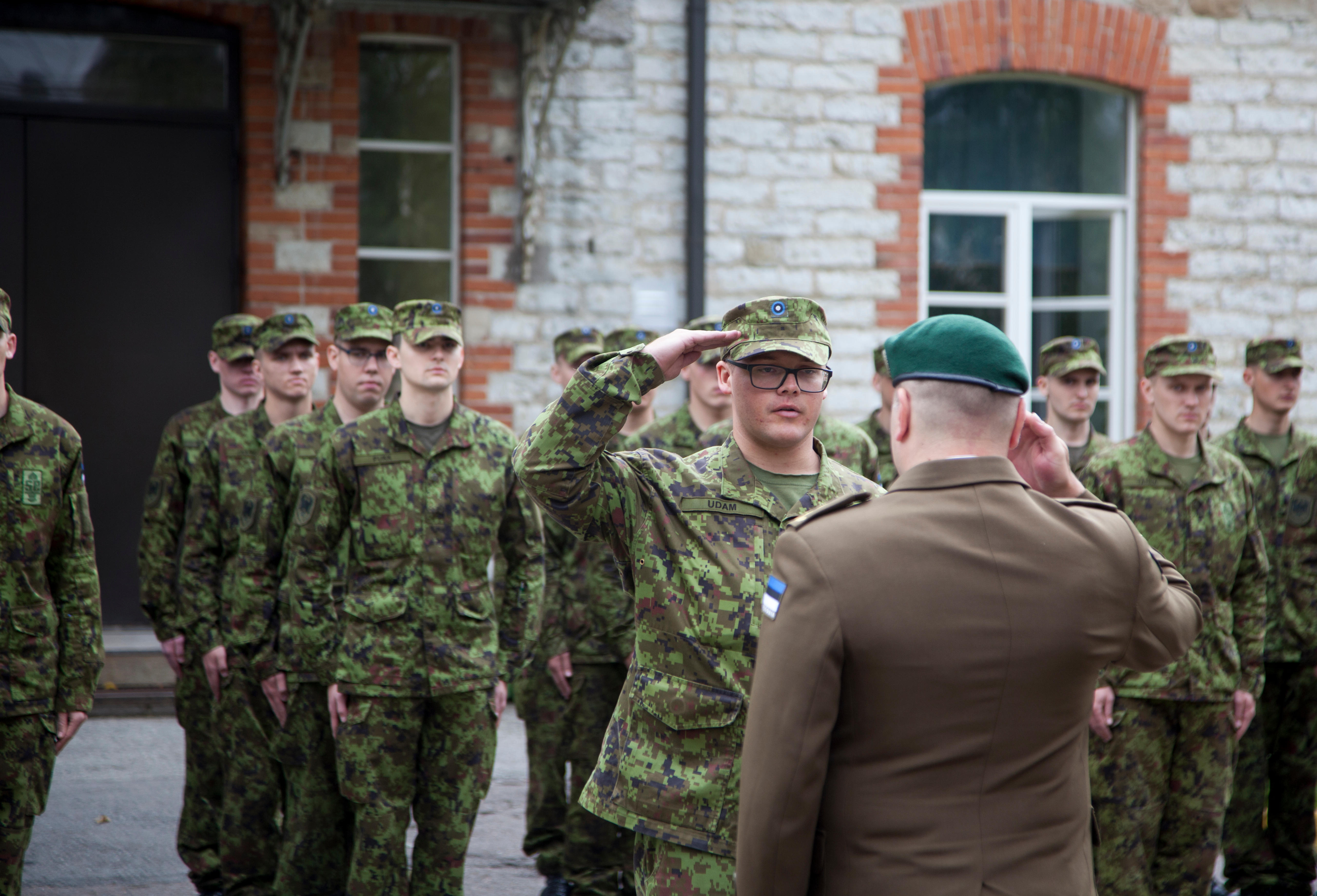 An Estonian conscript salutes Lt. Col. René Innos, battalion commander