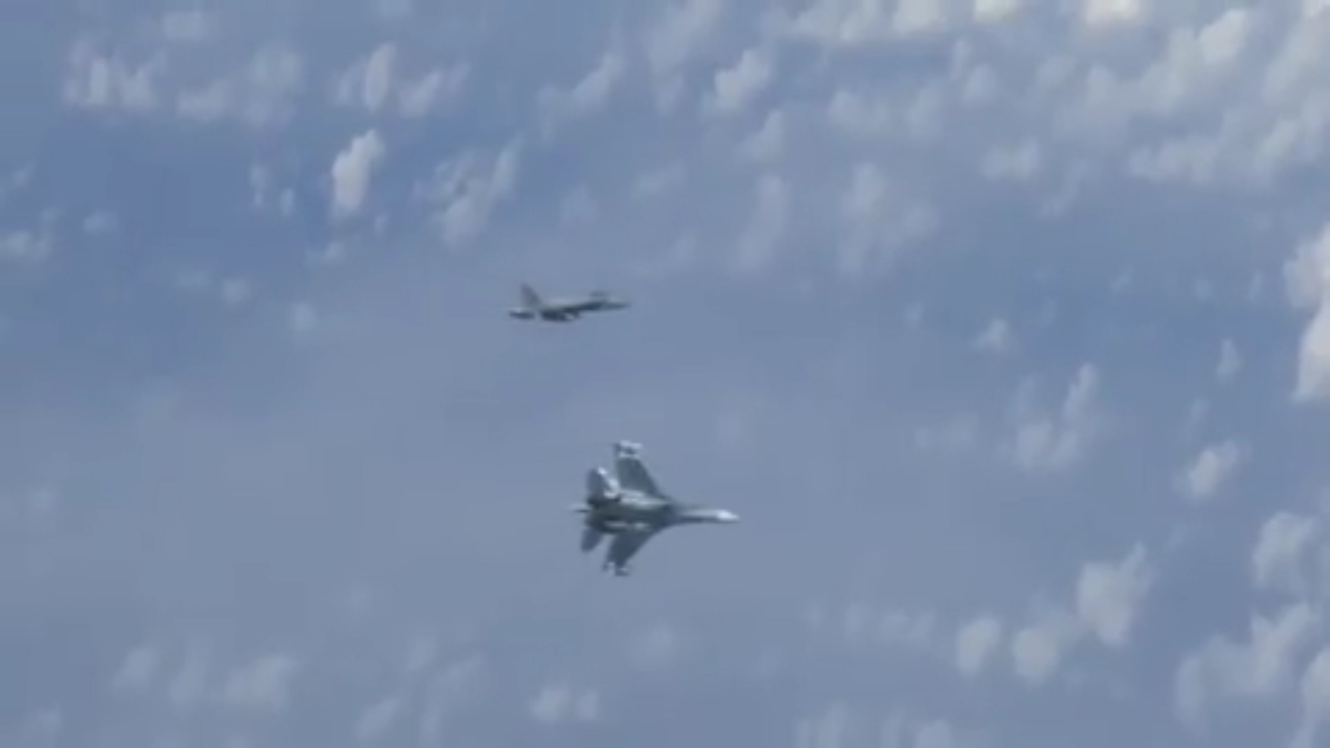Russian SU-27 wards off NATO F-18 after it flies too close to the Russian minister's plane.