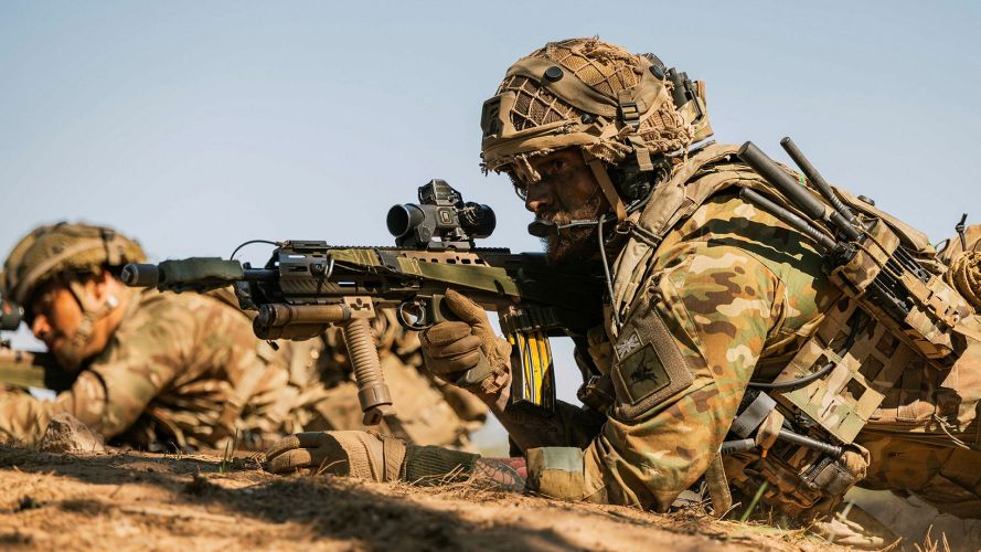 One para keeps an eye on the enemy while a fellow soldier from his section takes aim with his SA80 L85A3 One para keeps an eye on the enemy while a fellow soldier from his section takes aim with his SA80 L85A3