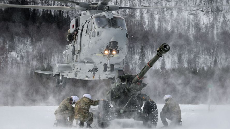 Personnel from 29 Commando Regiment Royal Artillery deployed in Norway shelter from downwash as they wait with a 105mm Light Gun to be lifted Personnel from 29 Commando Regiment Royal Artillery deployed in Norway shelter from downwash as they wait with a 105mm Light Gun to be lifted