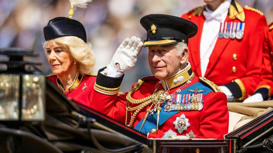 King Charles returns the salute while being driven down The Mall in his carriage - Queen Camilla's Grenadier Guards ensemble was made for her specially for the occasion King Charles returns the salute while being driven down The Mall in his carriage - Queen Camilla's Grenadier Guards ensemble was made for her specially for the occasion