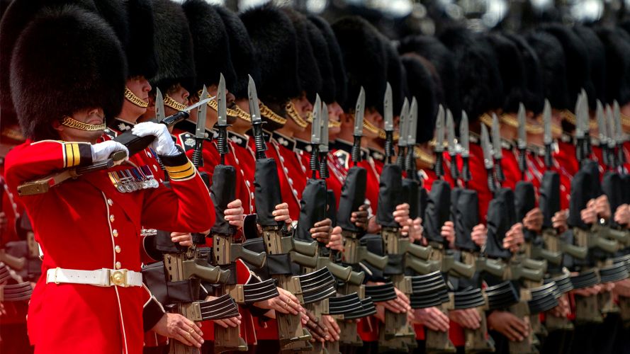 The right-hand marker protects the Colour, holding his SA80 L85 at the high ready position while the remainder of his guardsmen present arms The right-hand marker protects the Colour, holding his SA80 L85 at the high ready position while the remainder of his guardsmen present arms