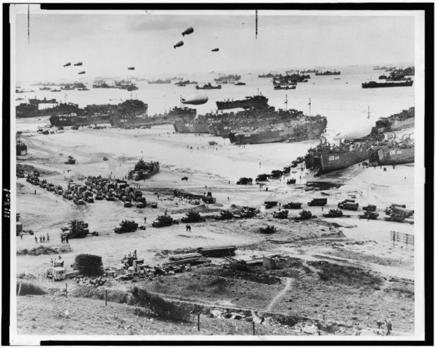 Landing craft, barrage balloons and Allied troops assault (Picture: US Maritime Commission). Landing craft, barrage balloons and allied troops assault a Normandy beach