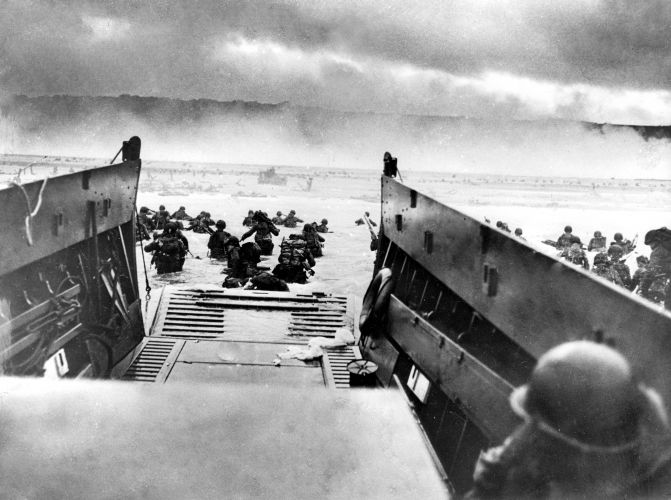 Troops wade ashore from a landing craft onto a Normandy beach (Picture: PA). Troops wade ashore from a landing craft onto a Normandy beach