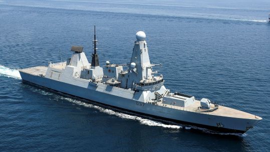 Despite arming up, defence officials have said HMS will not leave for Cyprus until next week