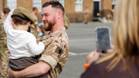 A PWRR soldier places his beret on his son's head after the parade, sharing a proud and heartfelt moment of love, family and homecoming (Picture: MOD)