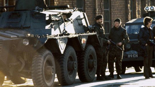 Soldiers supported by a Saracen armoured personnel carrier patrol a Catholic area of Belfast in 1973 - over half a century later the Troubles Bill may soon become law (Picture: Alamy)
