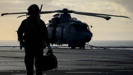 A crew member from 814 Naval Air Squadron walks out to their Merlin Mk2 on board HMS Prince of Wales during Operation Firecrest in the High North (Picture: MOD)