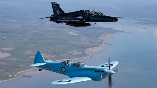The Spitfire TR9 flies alongside a Hawk T2 as it makes its way from Prestwick to RAF Valley