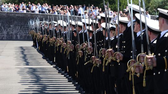 The newly-commissioned officers hold their ceremonial swords on the parade ground (Picture: Royal Navy)