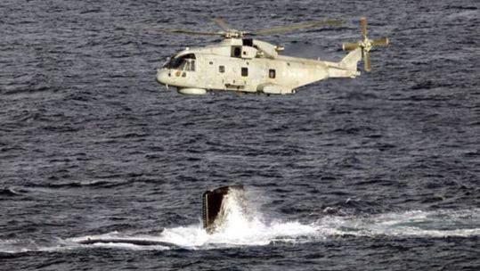 Merlin Mk2 flies over HMS Agamemnon's fin as she conducts diving trials (Picture: MOD)