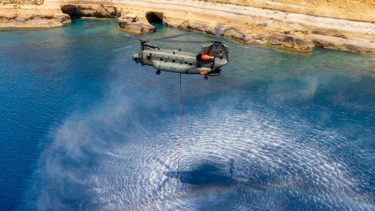 A firefighting Chinook from 1310 Flight fills its Bambi bucket with water during a training sortie ahead of the wildfire season in Cyprus (Picture: MOD)