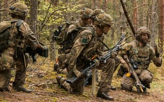 A designated marksman from A Company, 3 Para, briefs his section as they prepare to assault a US enemy position during Exercise Fly Trap