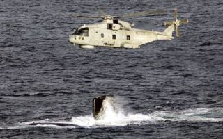 Merlin Mk2 flies over HMS Agamemnon's fin as she conducts diving trials (Picture: MOD)