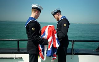 Leading Hand Kurt Tarrant and his fellow committals assistant carry out their duties committing ashes to the sea (Picture: BFBS)